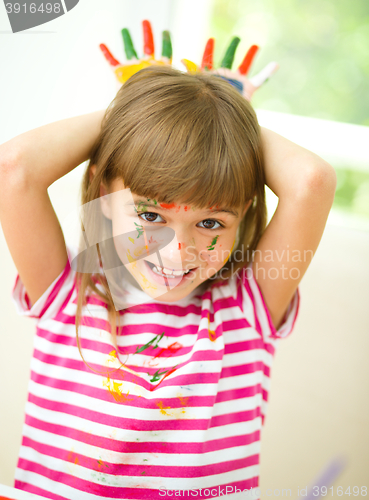Image of Portrait of a cute girl playing with paints