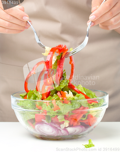 Image of Cook is mixing salad