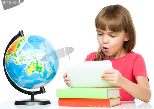 Image of Young girl is using tablet while studying