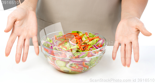 Image of Cook is presenting fresh salad