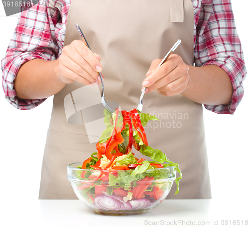 Image of Cook is mixing salad