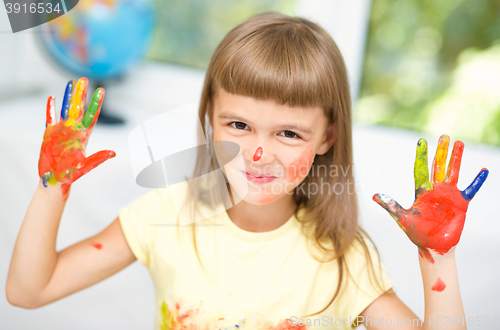 Image of Portrait of a cute girl playing with paints