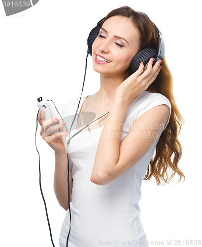 Image of Young woman enjoying music using headphones