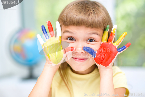 Image of Portrait of a cute girl playing with paints