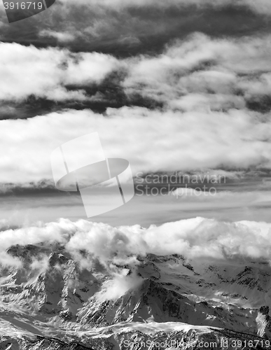 Image of Black and white sunlight snowy mountains in clouds