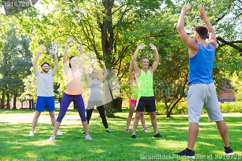 Image of group of friends or sportsmen exercising outdoors