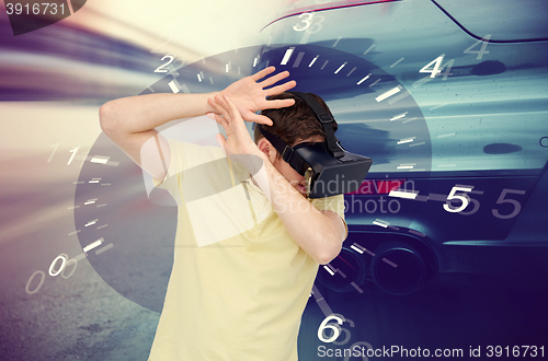 Image of man in virtual reality headset and car racing game