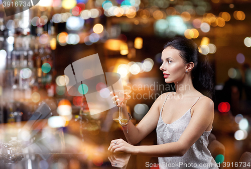 Image of glamorous woman with cocktail at night club or bar