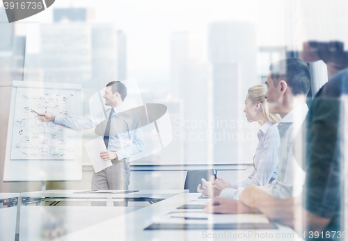 Image of group of smiling businesspeople meeting in office