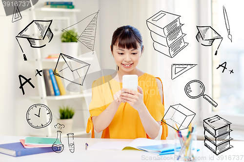 Image of happy young woman student with smartphone at home