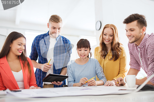 Image of creative team with blueprint working at office