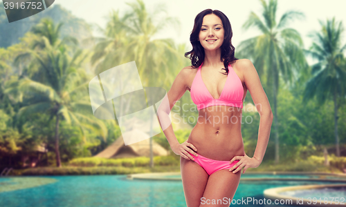 Image of happy young woman in pink bikini swimsuit