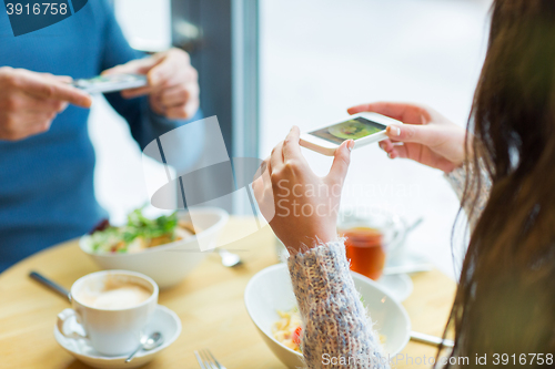Image of close up of couple picturing food by smartphone