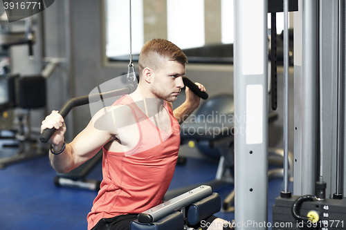 Image of man flexing muscles on cable machine gym