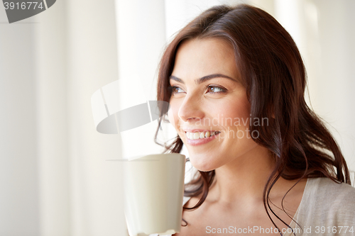 Image of happy woman with cup of tea or coffee at home