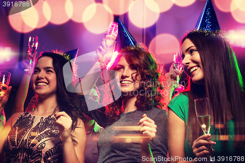 Image of smiling friends with glasses of champagne in club