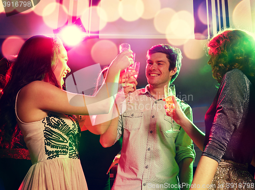 Image of smiling friends with glasses of champagne in club