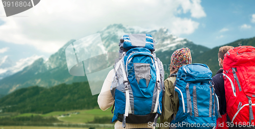 Image of travelers with backpacks hiking in mountains