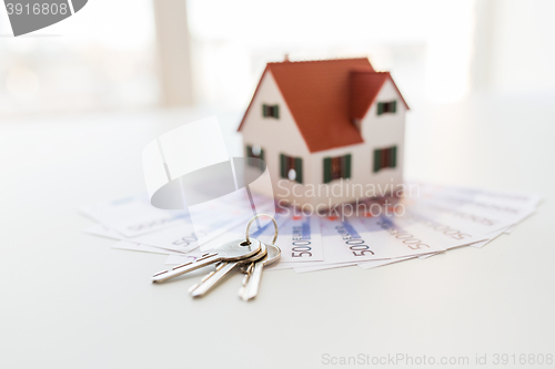 Image of close up of home model, money and house keys