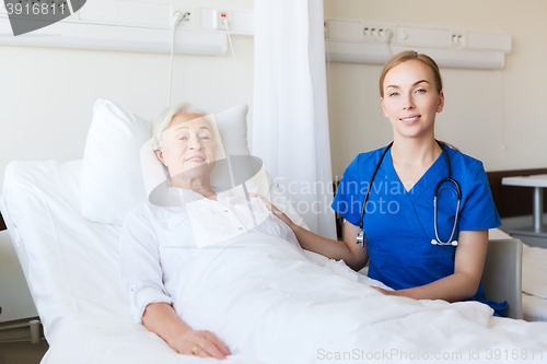 Image of doctor or nurse visiting senior woman at hospital