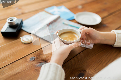 Image of close up of hands with coffee cup and travel stuff