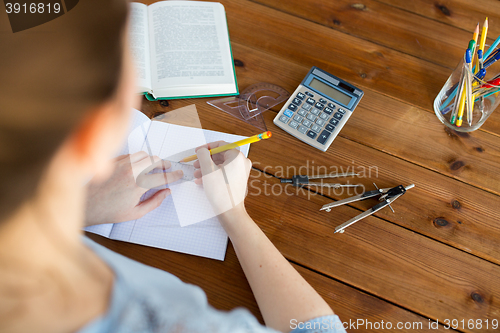 Image of close up of hands with ruler and pencil drawing