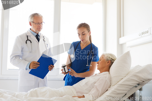 Image of doctor giving medicine to senior woman at hospital