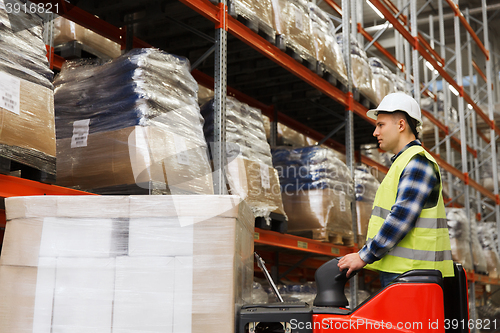 Image of man on forklift loading cargo at warehouse