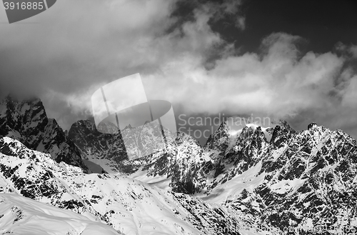 Image of Black and white snowy rocks in clouds