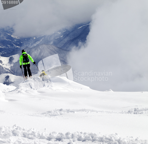 Image of Freeriders on off-piste slope and mountains in mist