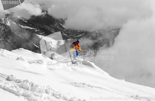 Image of Snowboarder on off-piste slope an mountains in fog. Selective co