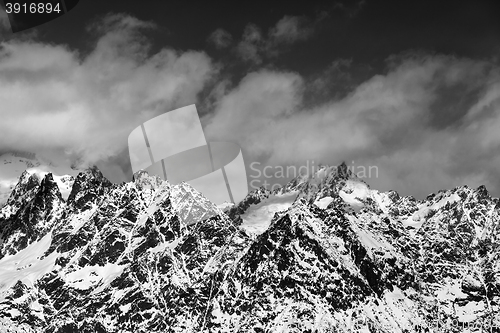 Image of Black and white snowy rocks at sunny day