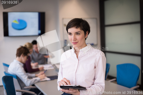 Image of hispanic businesswoman with tablet at meeting room