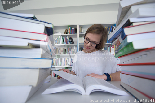 Image of female student study in library, using tablet and searching for 