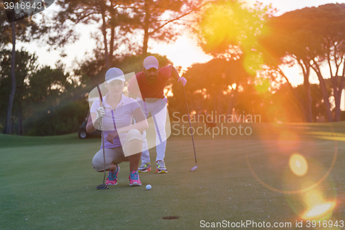 Image of couple on golf course at sunset