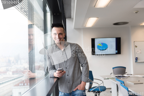 Image of young business man using smart phone at office