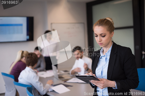 Image of business woman working on tablet at meeting room