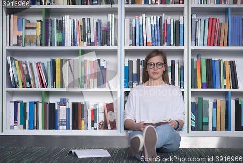 Image of female student study in library, using tablet and searching for 