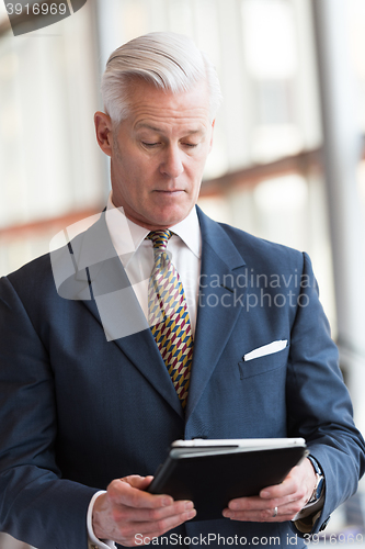 Image of senior business man working on tablet computer