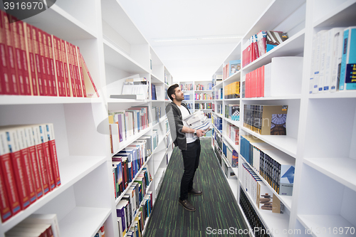 Image of Student holding lot of books in school library