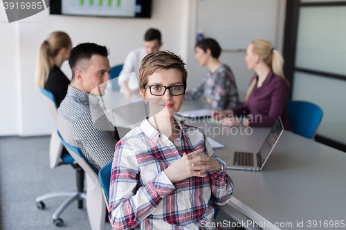 Image of portrait of young business woman at office with team on meeting 