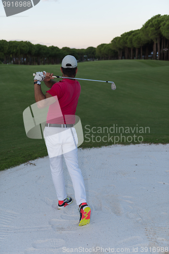 Image of golfer hitting a sand bunker shot on sunset