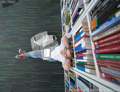 Image of female student study in library, using tablet and searching for 