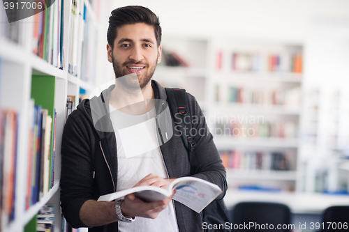 Image of portrait of student while reading book  in school library