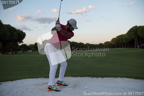 Image of golfer hitting a sand bunker shot on sunset