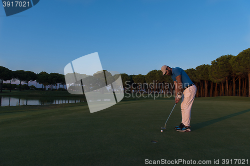 Image of golfer  hitting shot at golf course