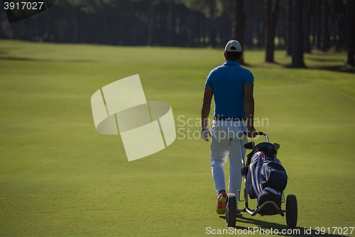 Image of golf player walking with wheel bag