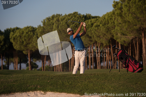 Image of golfer hitting a sand bunker shot on sunset