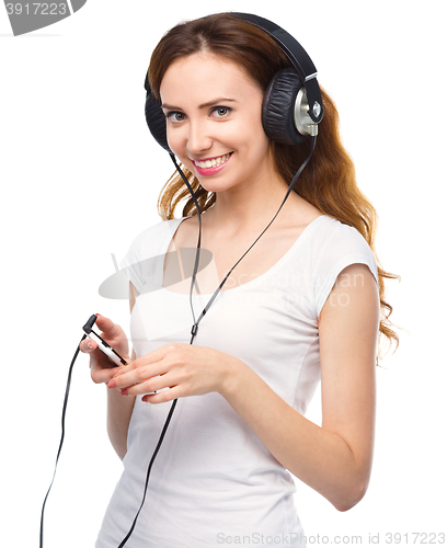 Image of Young woman enjoying music using headphones