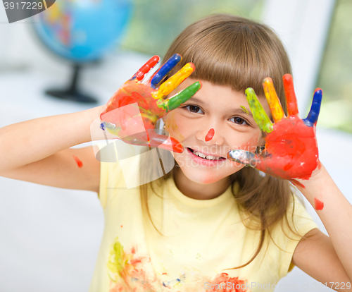 Image of Portrait of a cute girl playing with paints
